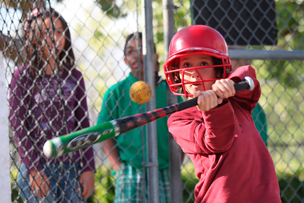 Child batting at Murrieta family attraction with pitching cages