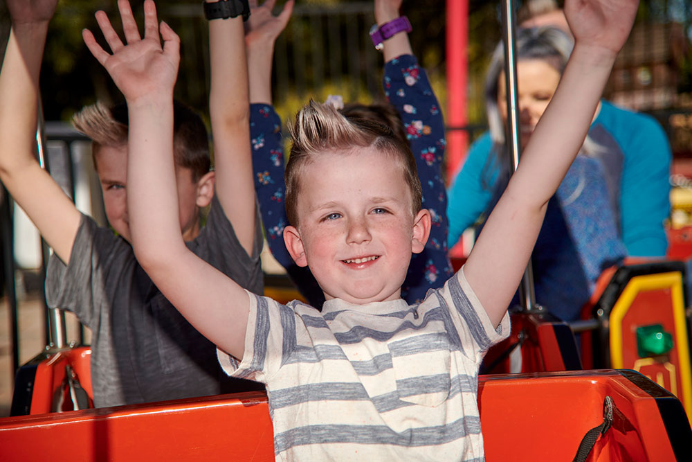 Excited child enjoying Murrieta kiddie ride at Mulligan