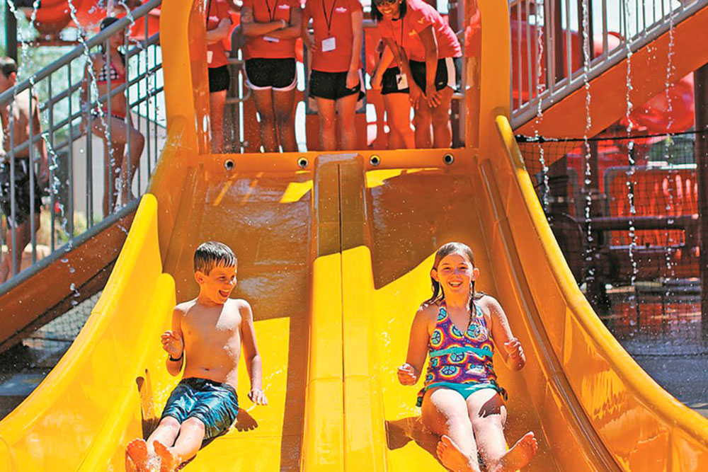 Children racing down slides at Temecula outdoor water attraction