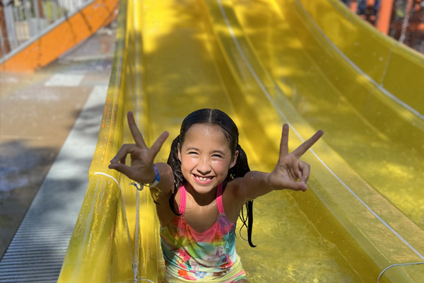 Excited child enjoying water slides at kids attraction in Temecula, CA