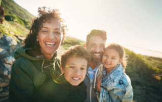 Holiday, mountain and portrait of family with smile, nature and outdoor bonding together on travel adventure. Mom, dad and children on summer vacation with hiking, happy face and sunshine on hill