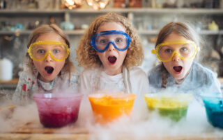 Children wearing goggles doing colorful volcano science experiment. amazed kids in safety goggles doing a colorful science experiment with smoke effects at home, concept of fun learning